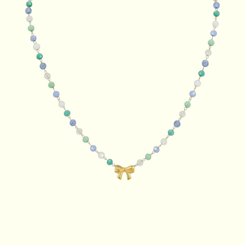Necklace with colorful beads and a gold bow charm on a white background