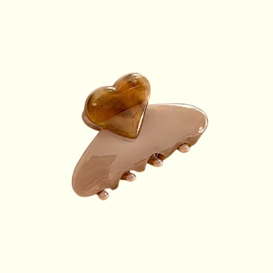 Beige hair clip with a heart-shaped design on a white background