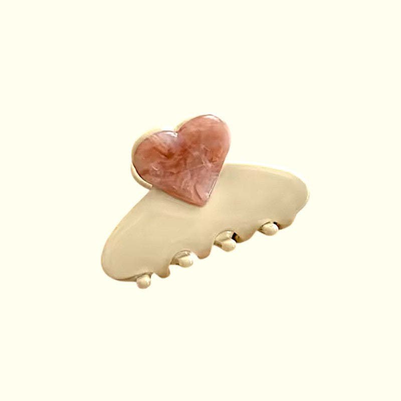 Hair clip with a heart-shaped pink stone on a white background