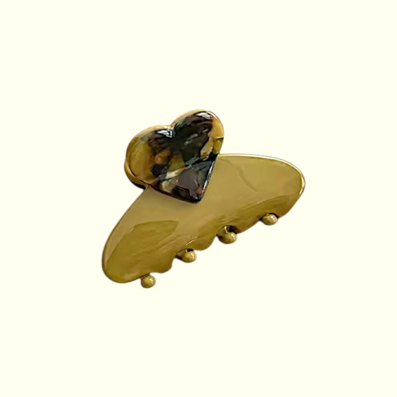 Gold hair clip with a tortoiseshell design on a white background