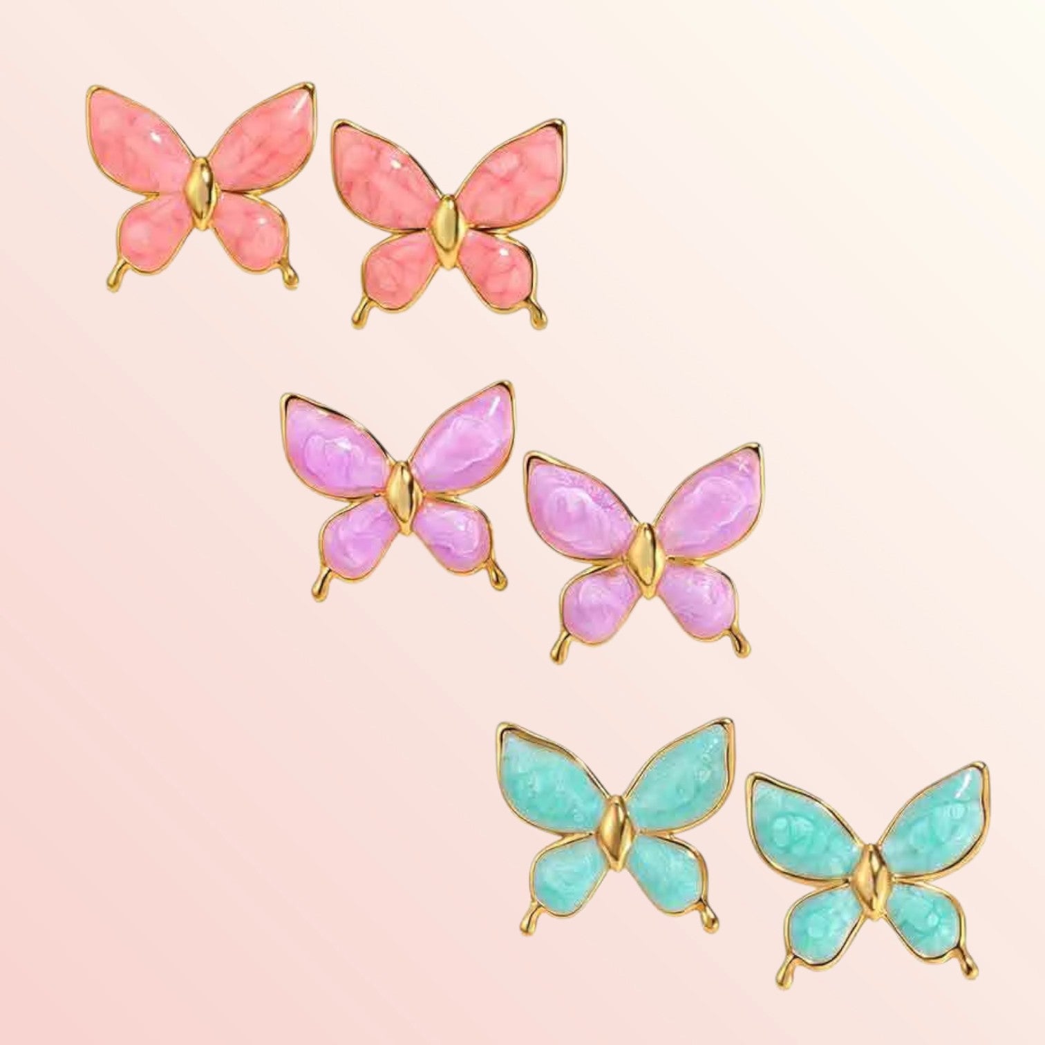 Butterfly-shaped earrings in pink, purple, and blue on a pink background