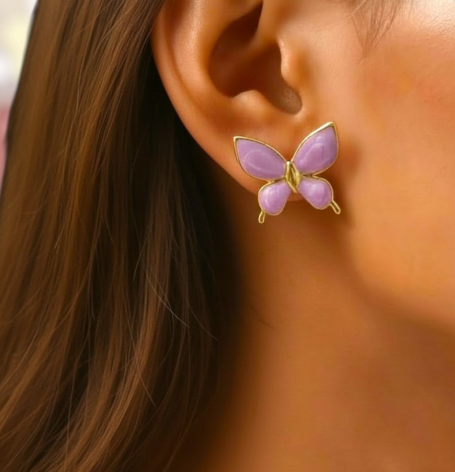 Butterfly-shaped earring worn on an ear with a blurred background