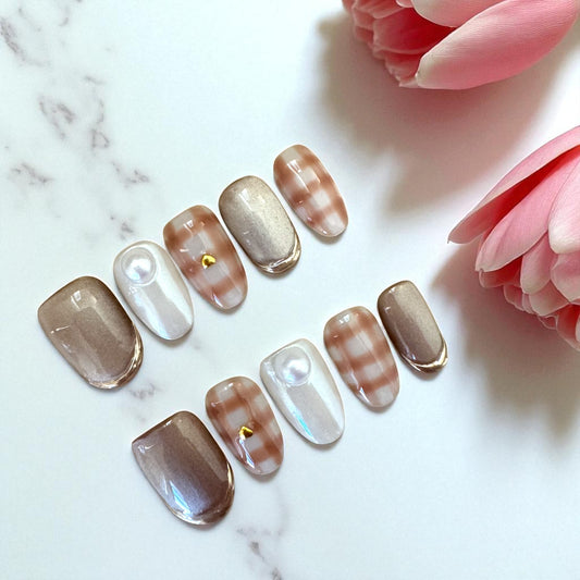 Set of nail art samples on a marble surface with pink flowers.