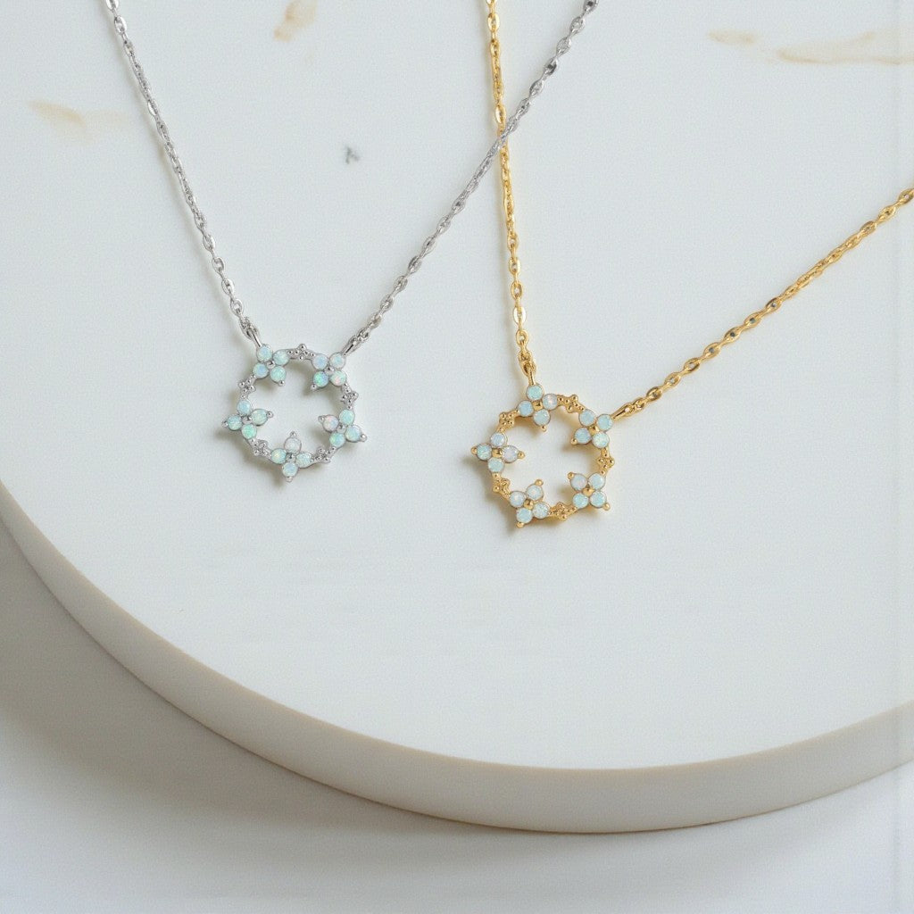 Two necklaces with floral pendants on a white surface