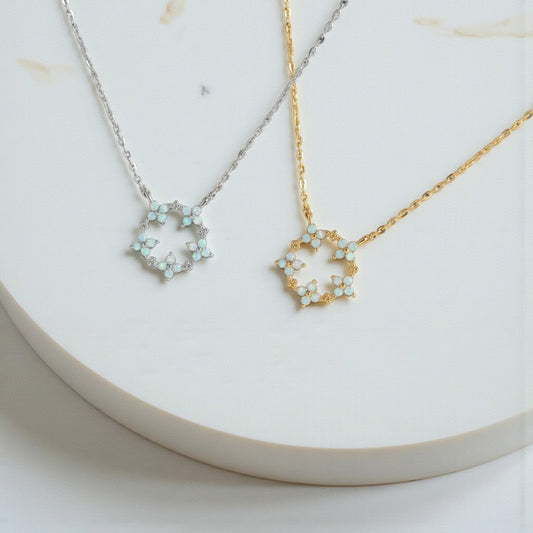 Two necklaces with floral pendants on a white surface