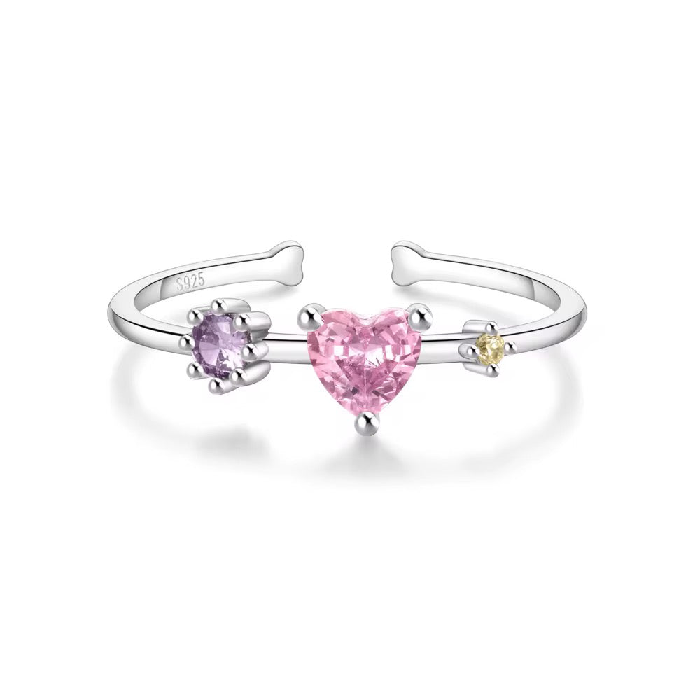 Silver open ring with heart-shaped pink gemstones on a white background