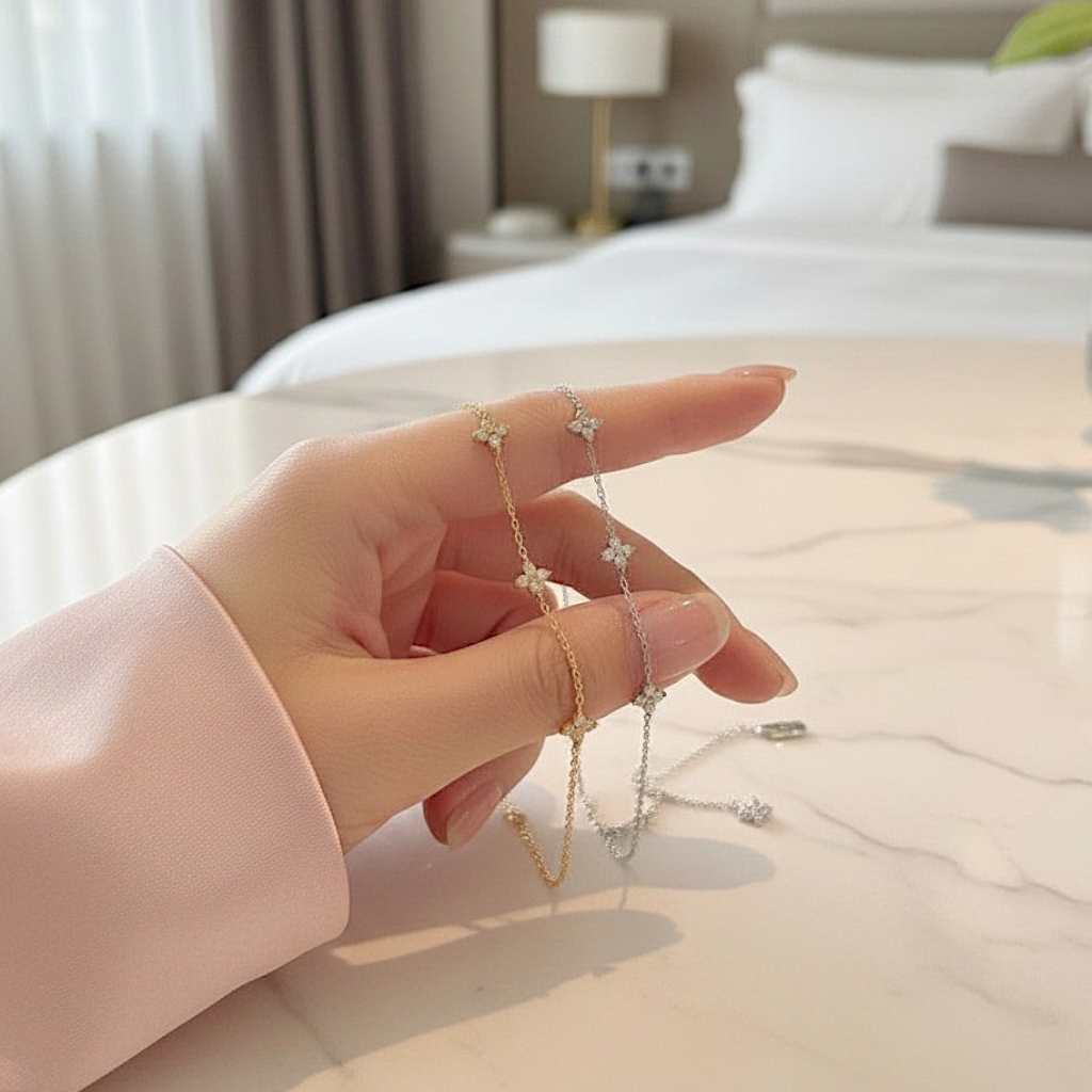 Hand holding two bracelets on a blurred bedroom background