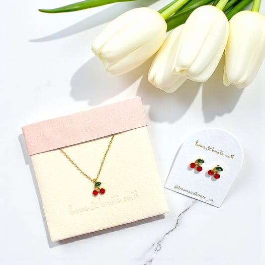 Jewelry set with necklace and earrings on display with tulips in the background