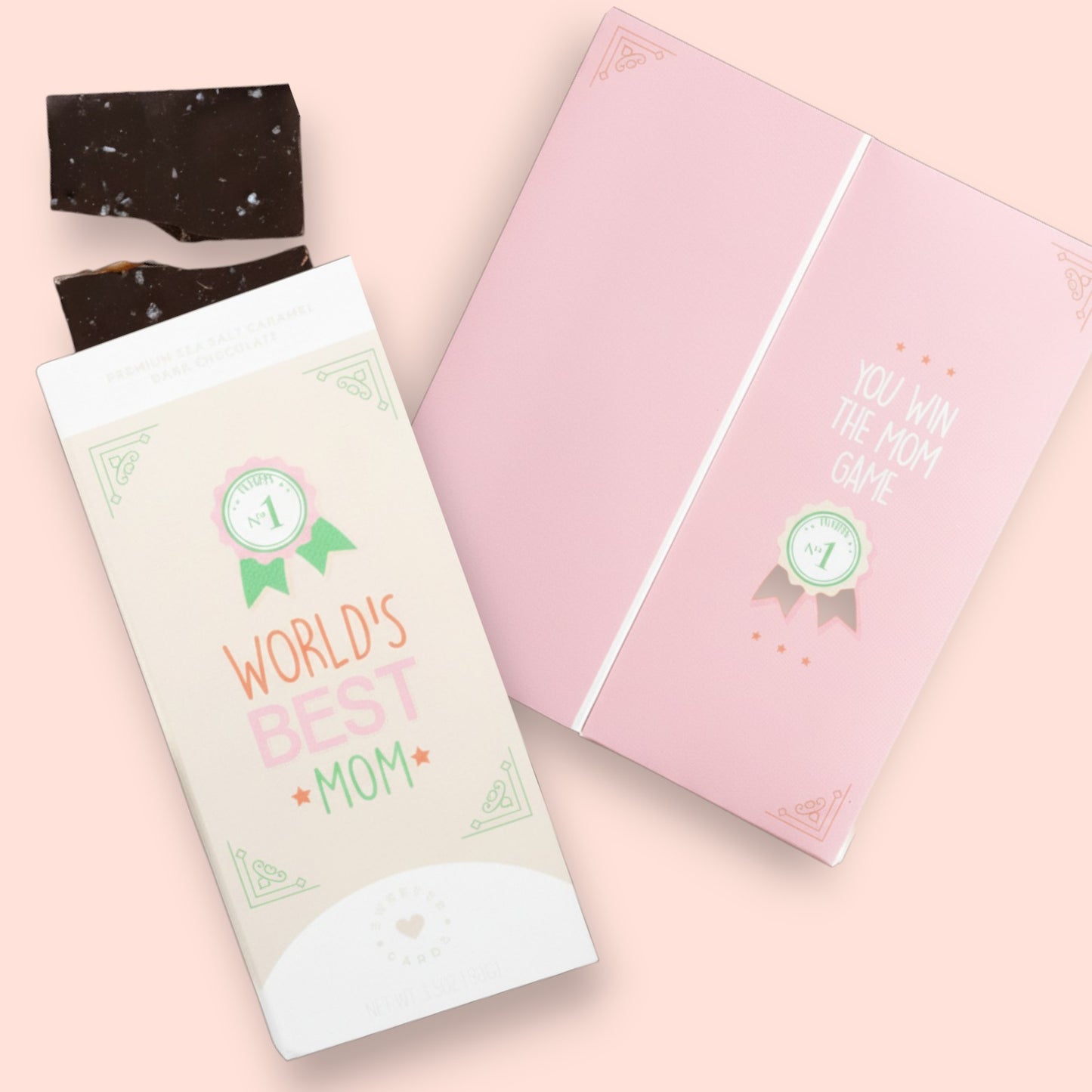 Two chocolate bars with decorative packaging on a pink background