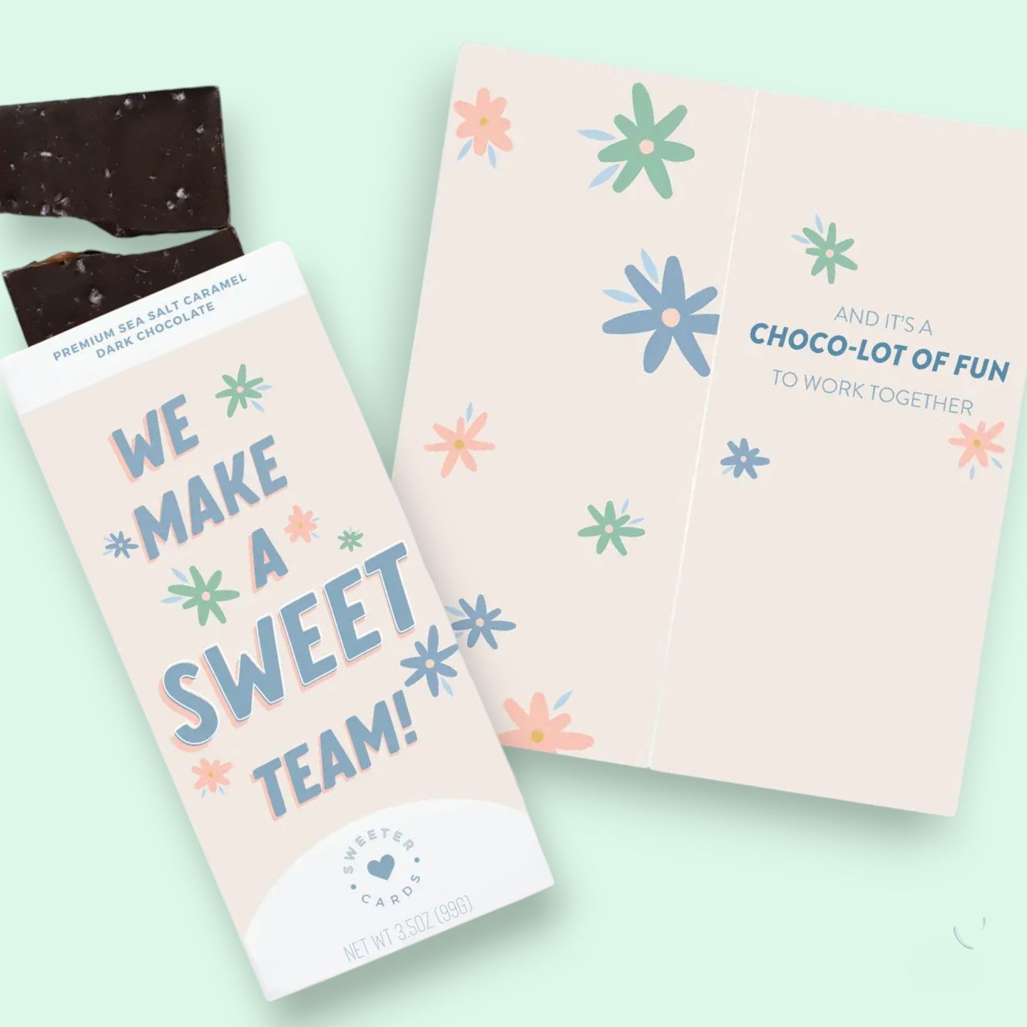 Chocolate bar with a pink packaging featuring text and floral designs on a light green background