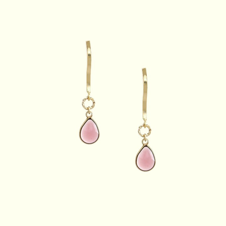 Pair of gold earrings with pink teardrop-shaped stones on a white background