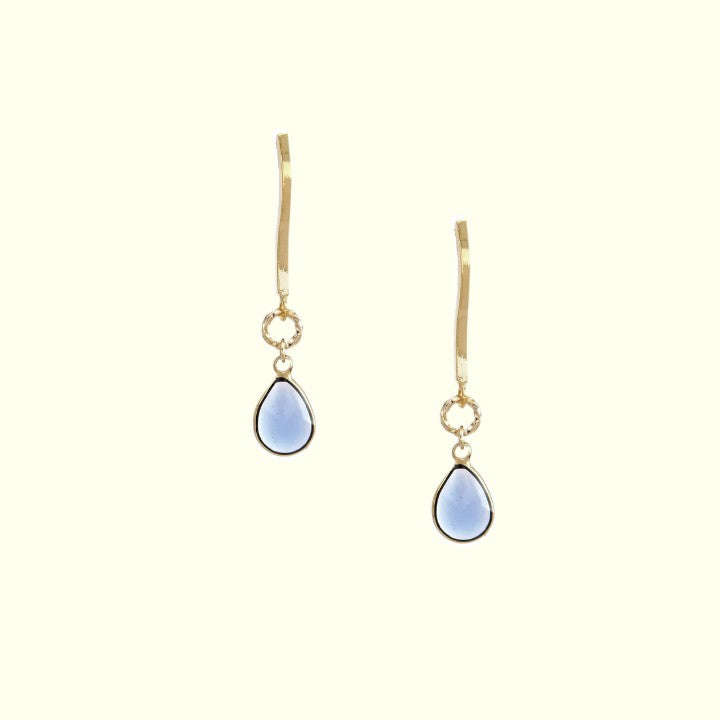 Gold earrings with blue teardrop-shaped stones on a white background