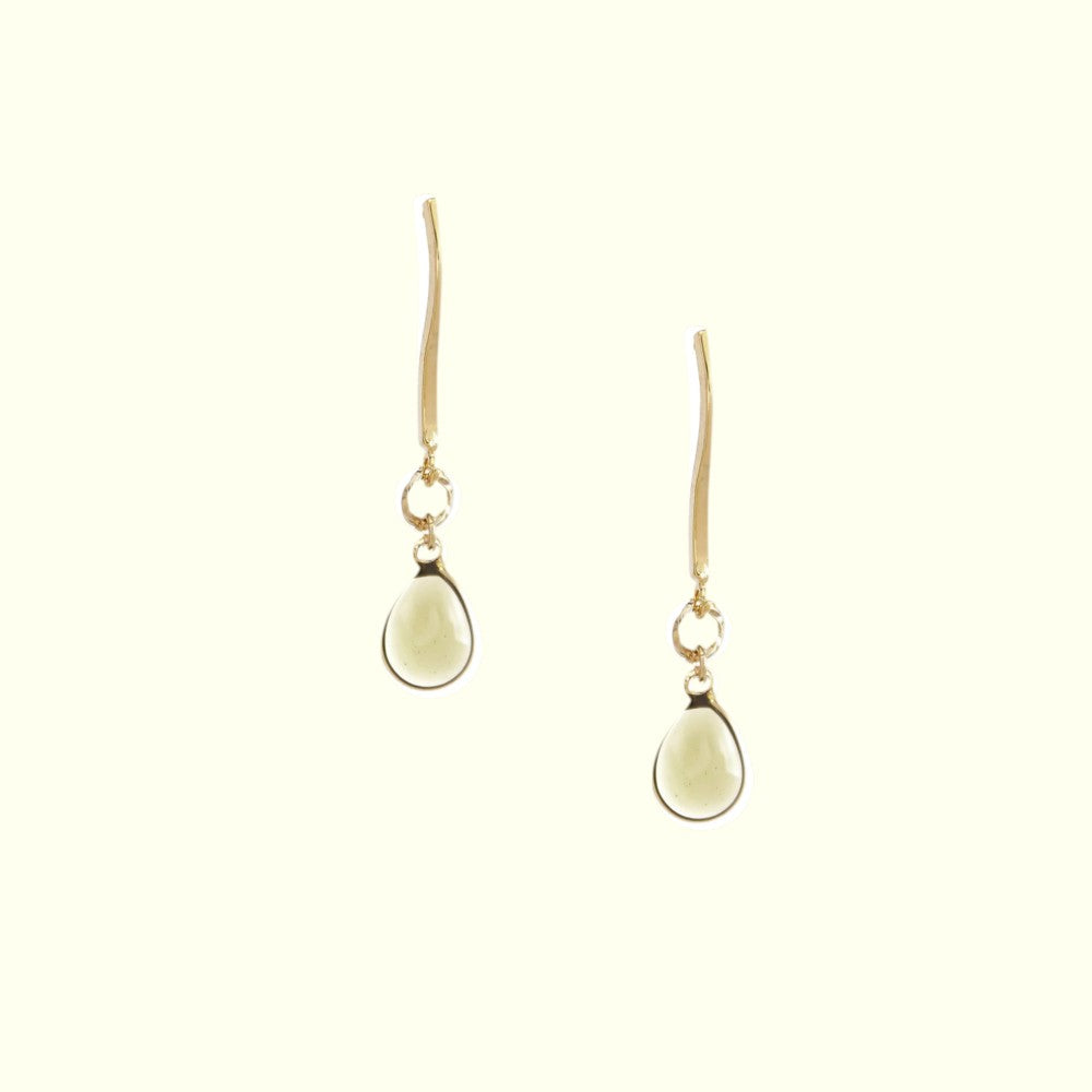 Pair of gold earrings with teardrop-shaped stones on a white background