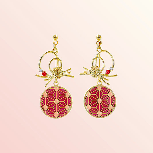 Gold earrings with pink geometric designs on a light pink background
