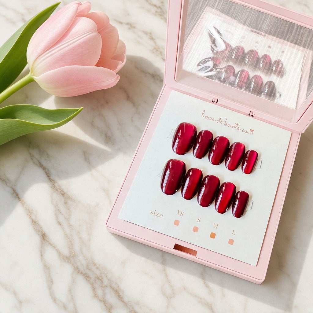 Deep burgundy wine-red handmade press-on nails with a high-shine glossy finish and elegant almond-shaped tips by Bows and Knots Co.