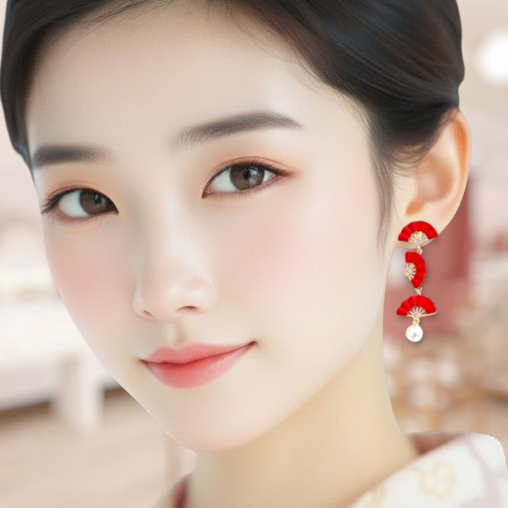 Close-up of a woman wearing red earrings with a blurred background