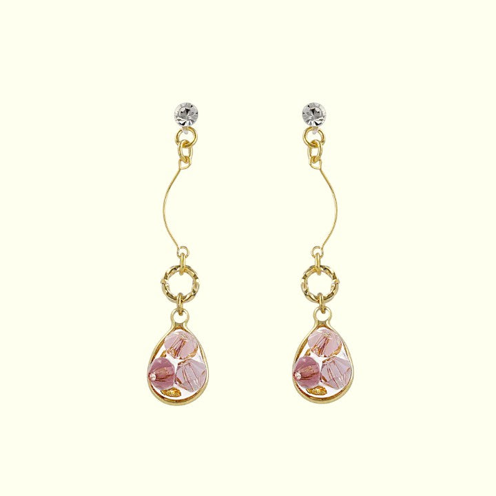 Gold earrings with pink teardrop-shaped stones on a white background