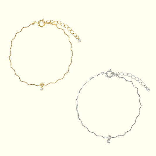 Gold and silver anklets on a white background