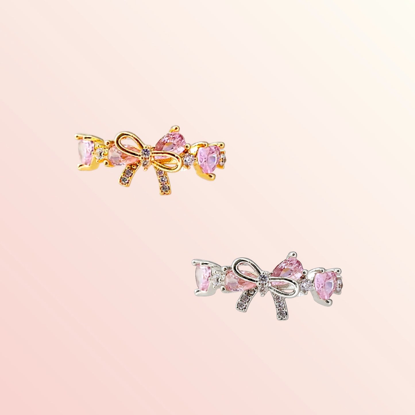 Two bow-shaped earrings with pink gemstones on a light pink background