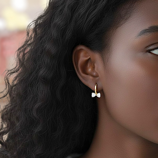 Close-up of a person wearing a bow-shaped earring with a blurred background