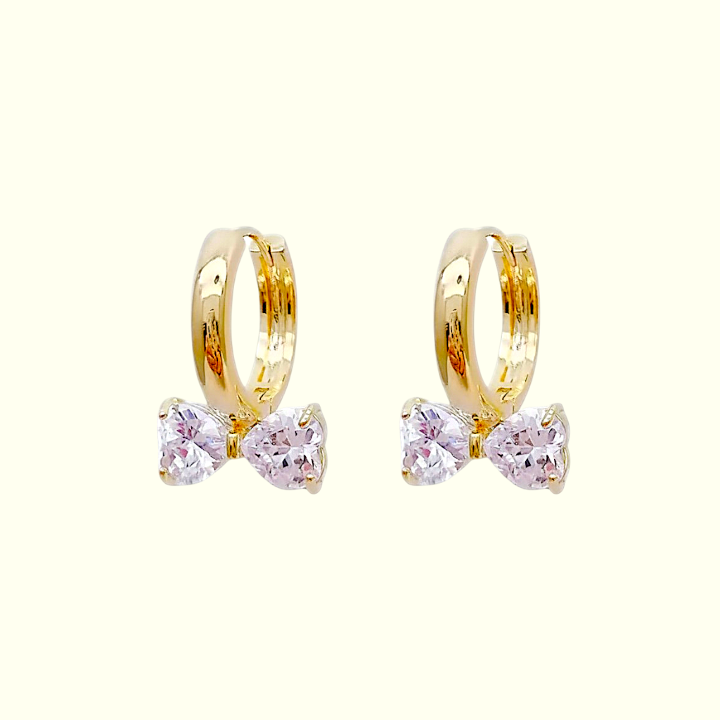 Gold hoop earrings with pink gemstones on a white background