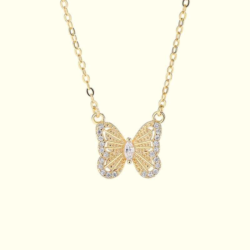 Gold butterfly necklace on a white background