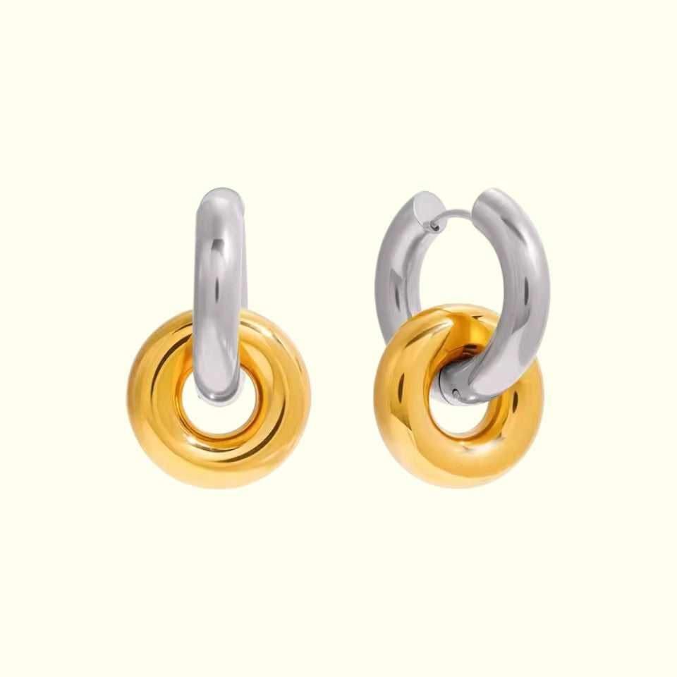 Pair of hoop earrings with gold and silver finish on a white background