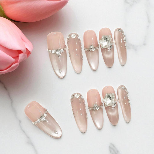 Decorative nails with crystals on a white background with pink flowers