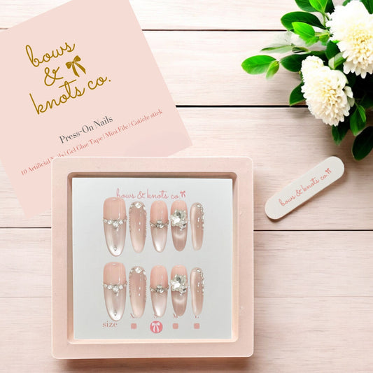 Press-on nails set with packaging and decorative elements on a wooden surface