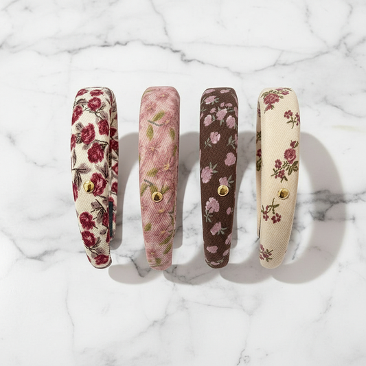 Four floral-patterned headbands on a marble background
