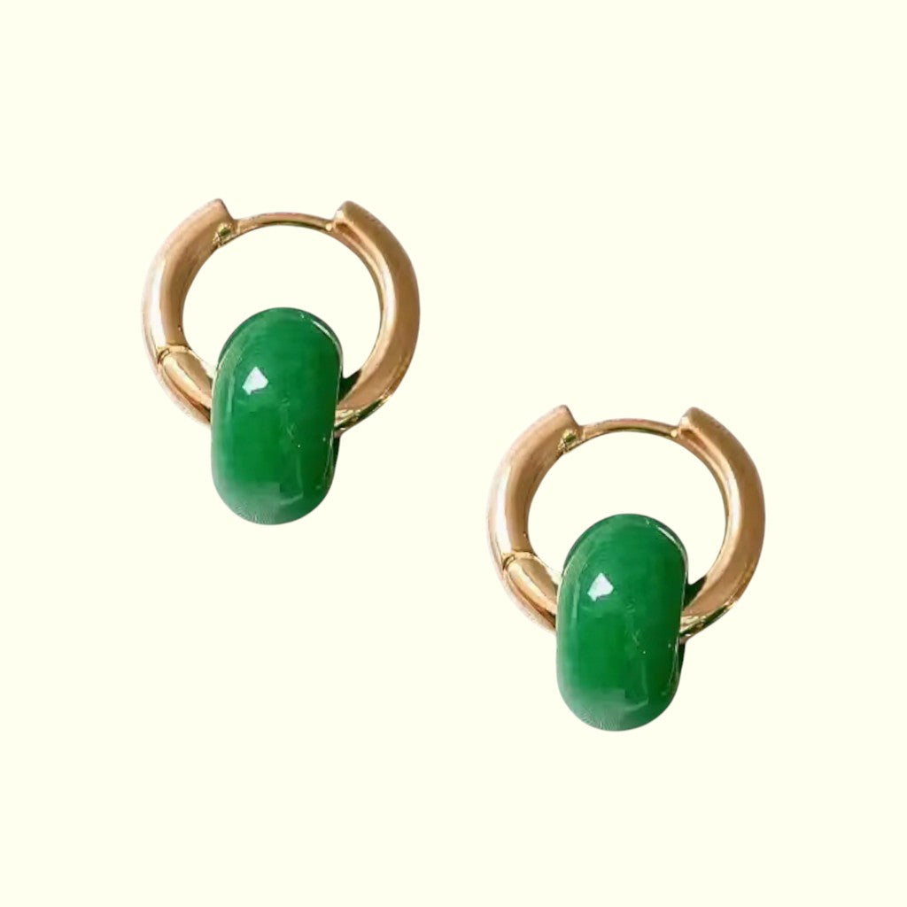 Pair of gold hoop earrings with green oval stones on a white background