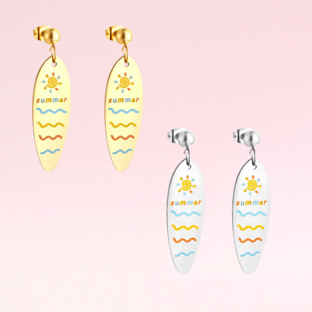 Two pairs of surfboard-shaped earrings on a pink background