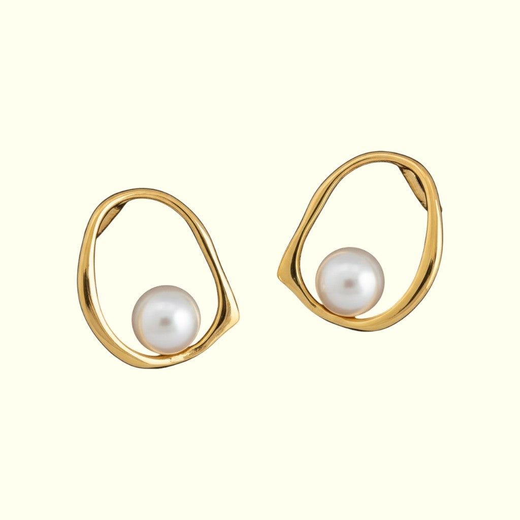 Gold earrings with pearls on a white background
