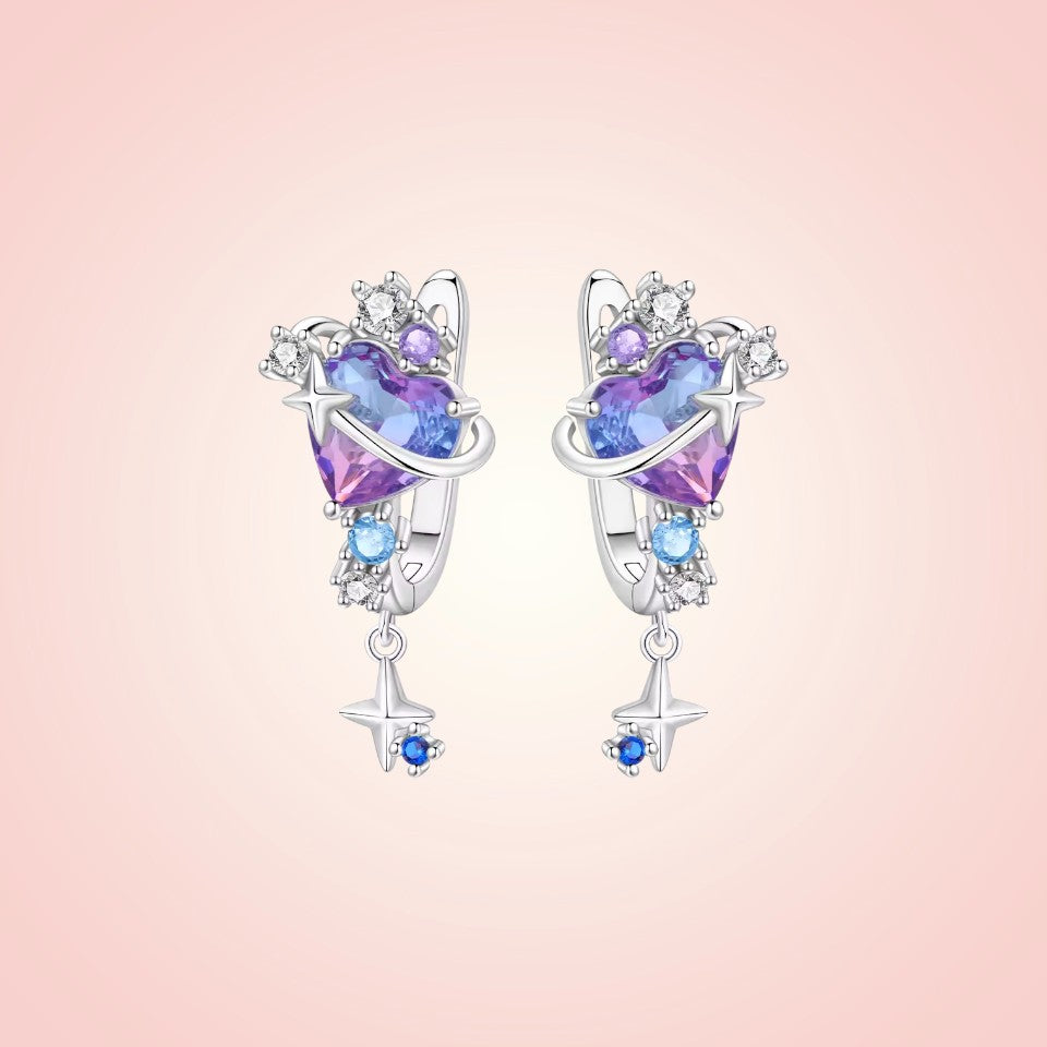 Pair of heart-shaped earrings with colorful gemstones on a pink background