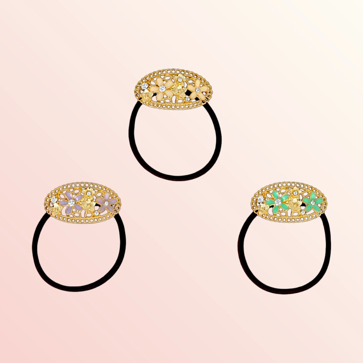 Three decorative hair ties with gold and gemstone embellishments on a pink background