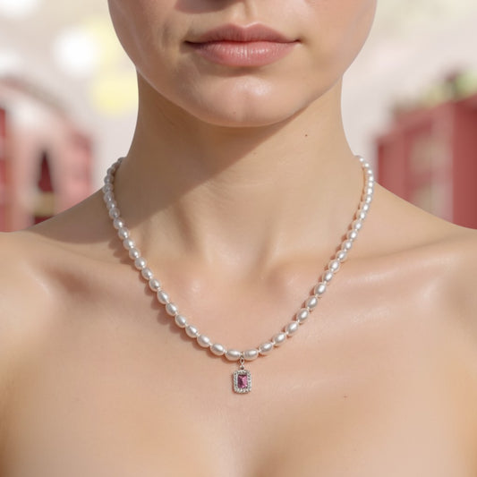 Pearl necklace with a pendant worn by a person, blurred background