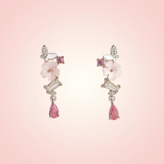 Pair of earrings with pink gemstones on a pink background
