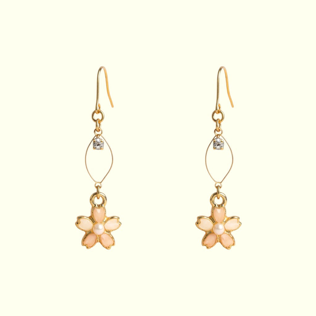 Pair of flower-shaped earrings with gold and pink details on a white background