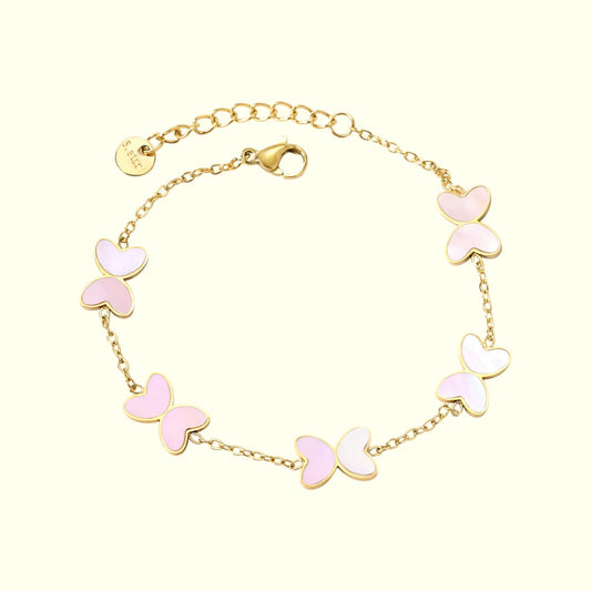 Gold bracelet with pink butterfly charms on a white background