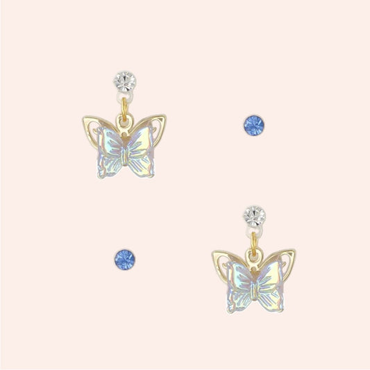 Butterfly-shaped earrings with gemstones on a light pink background