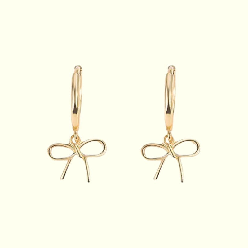 Gold bow-shaped earrings on a white background