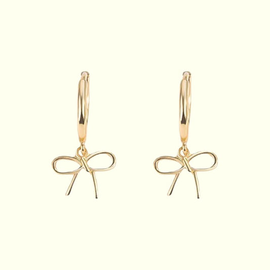 Gold bow-shaped earrings on a white background