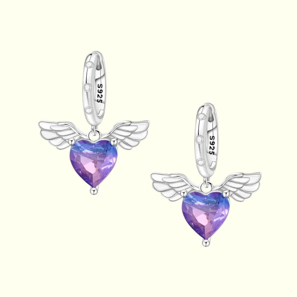 Heart-shaped earrings with wings on a white background