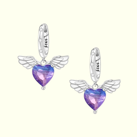 Heart-shaped earrings with wings on a white background