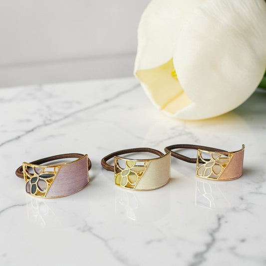 Three decorative rings with gold and brown accents on a marble surface.