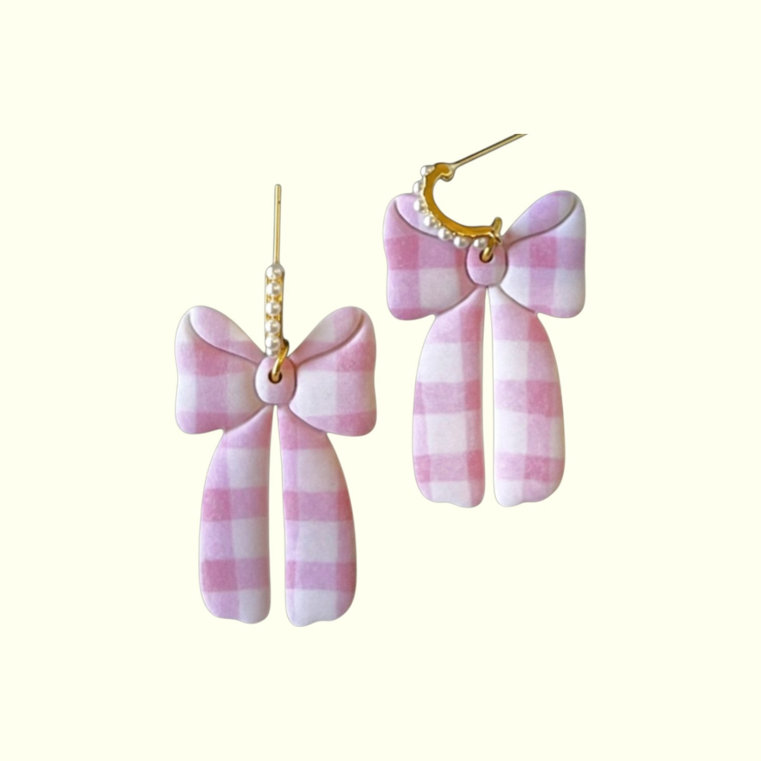 Pink and white checkered bow earrings on a white background