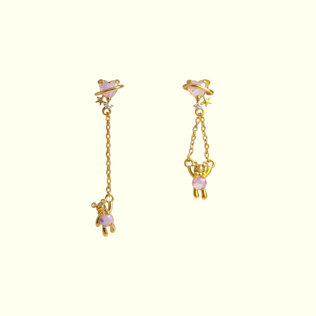 Gold earrings with pink gemstones on a white background