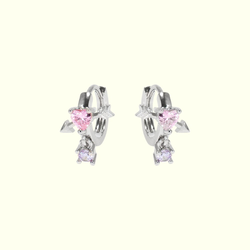 Pair of silver hoop earrings with pink heart-shaped gemstones on a white background