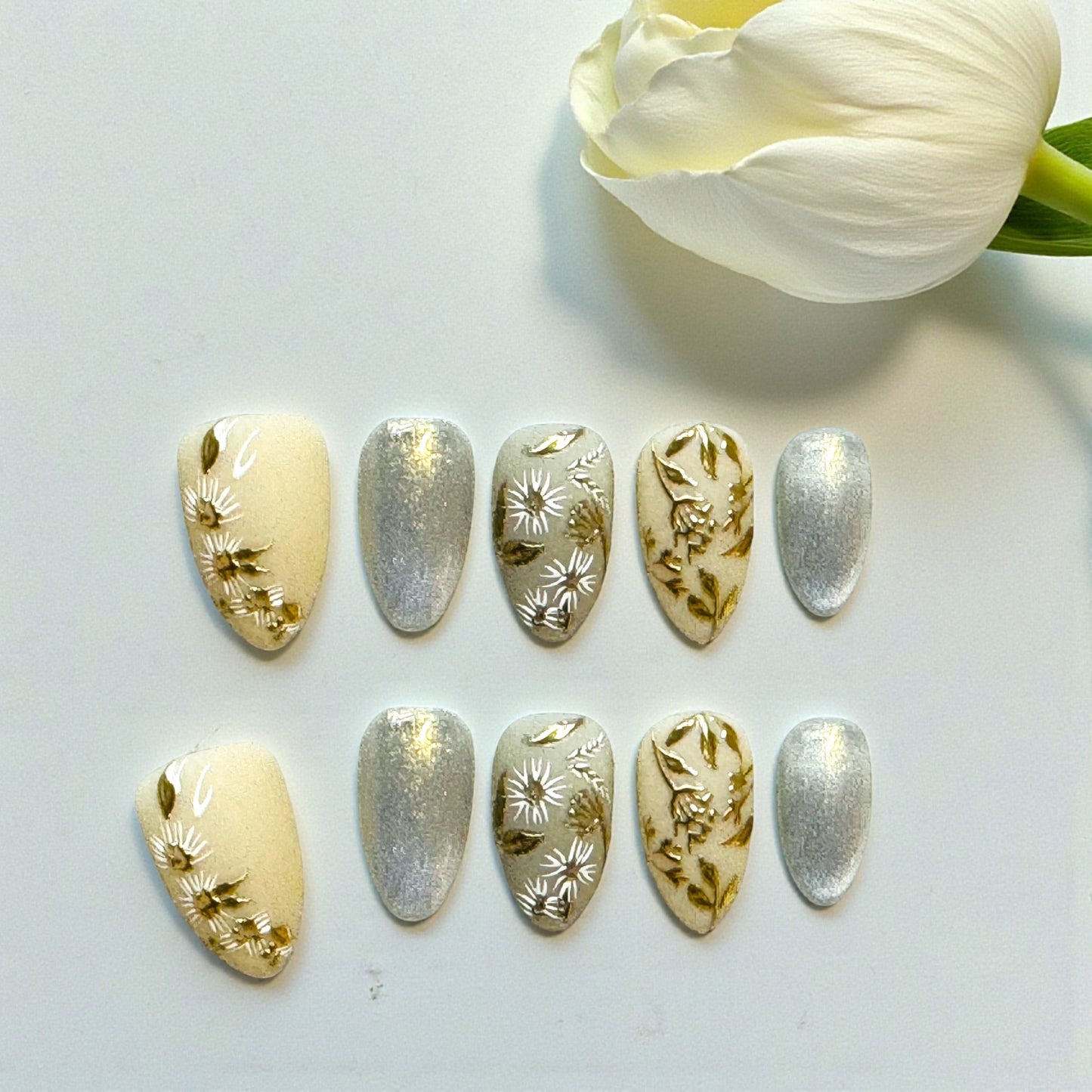 Set of decorative nail art sheets with floral designs on a light background.