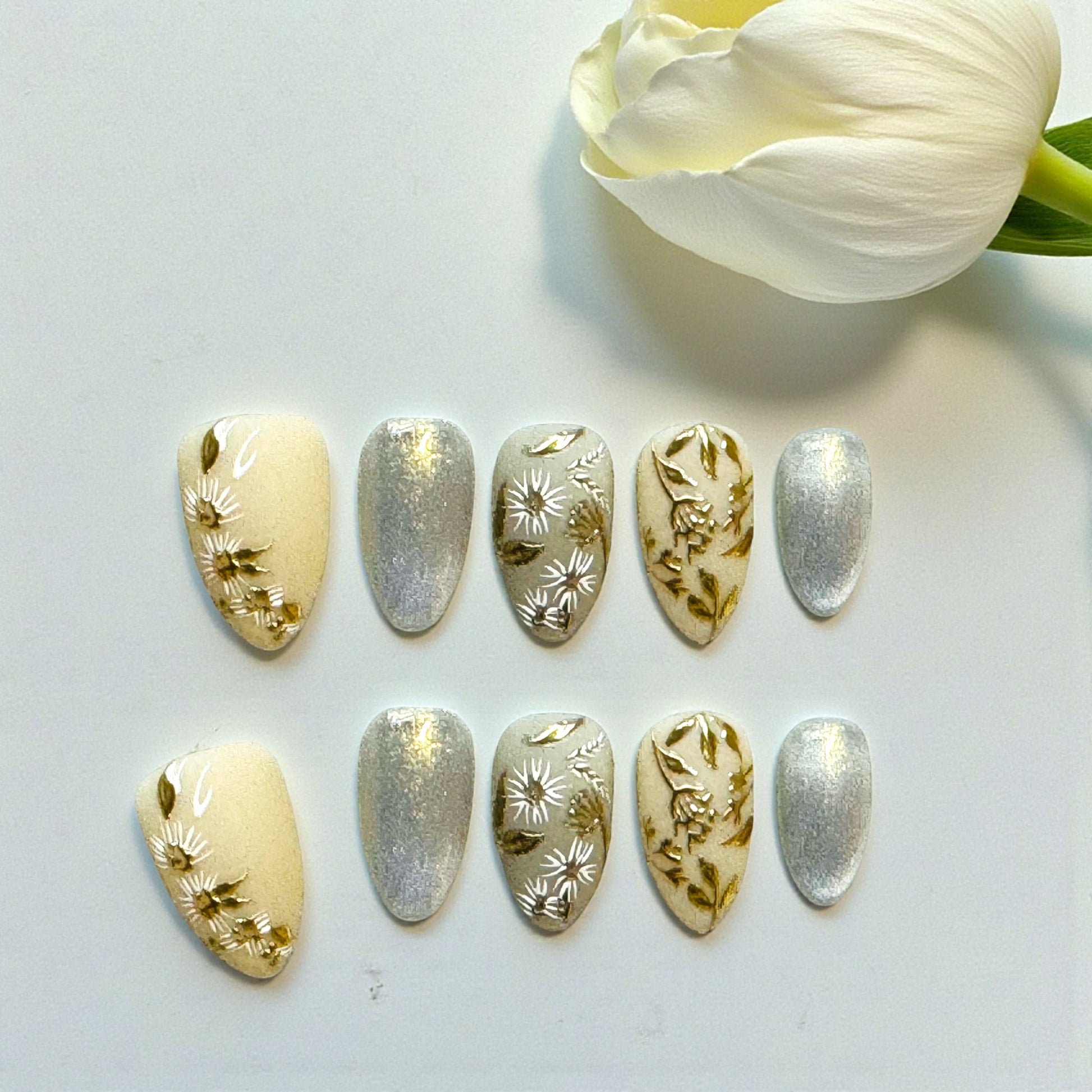 Set of decorative nail art sheets with floral designs on a light background.